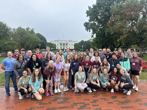 Students take a group picture in front of the White House